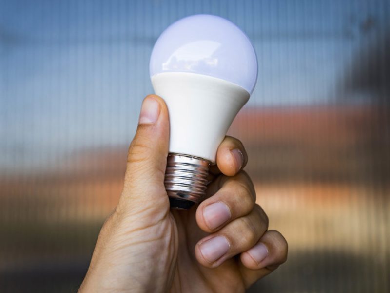 a close-up image of an LED light bulb being held in a hand