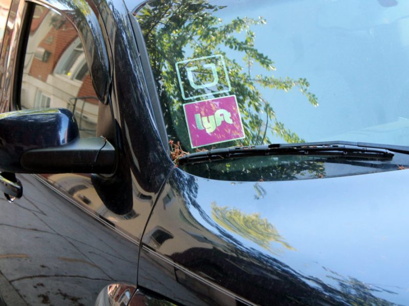 a car windshield with Uber and Lyft stickers