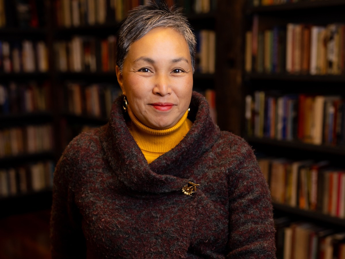 A portrait of Annamaria Leon with bookshelves in the background.