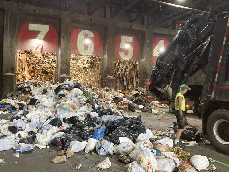 A worker unloads a garbage truck at EcoMaine in June 2021, in Portland, Maine.