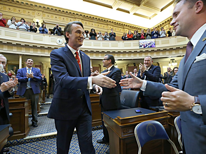 Virginia Gov. Glenn Youngkin, left, shakes hands with Attorney General Jason Miyares, right, as Youngkin enters the Virginia House of Delegates to give his State of the Commonwealth speech at the State Capitol in Richmond, on Monday, Jan. 17, 2022.