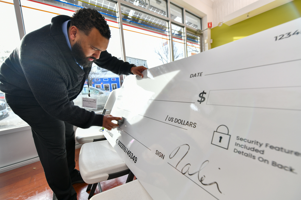 Writing on an oversized check.