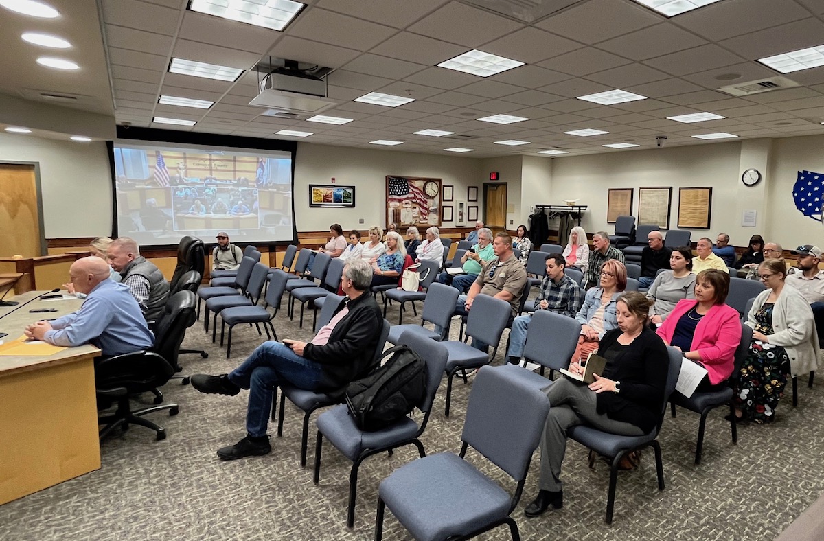 A few rows of seats in a county office are about half full.