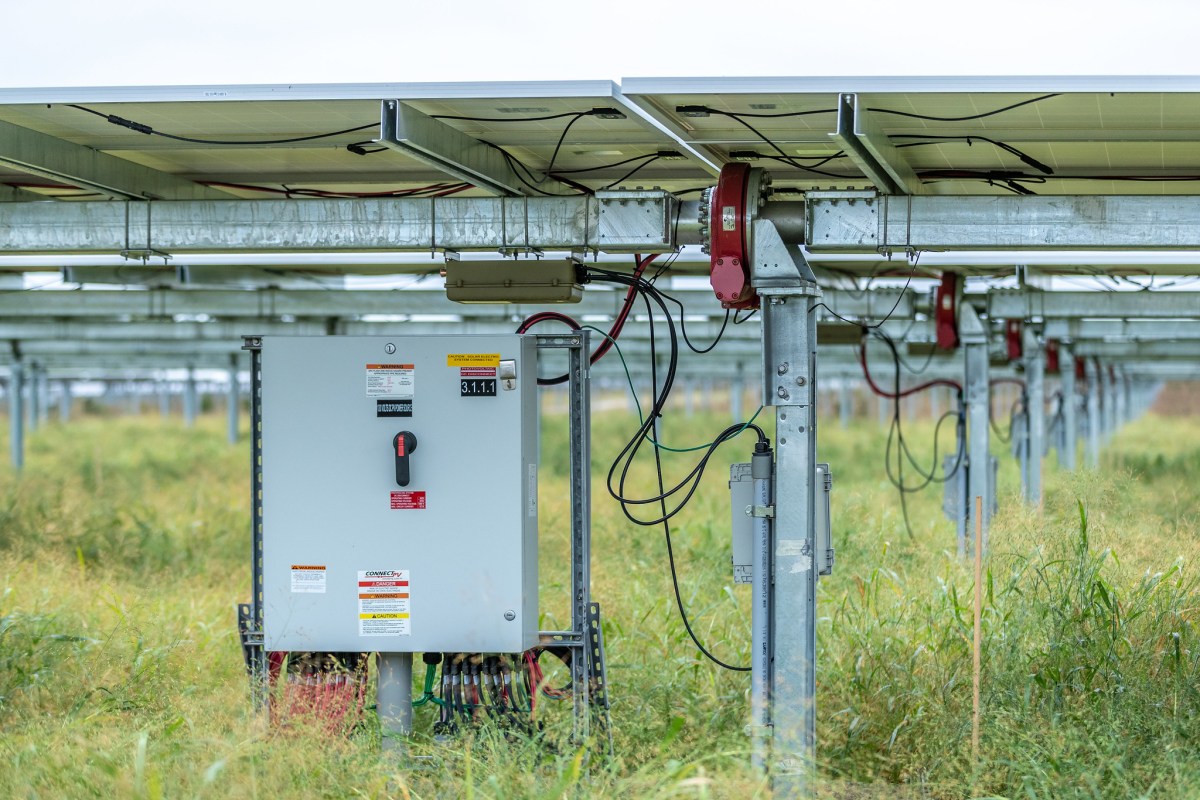 An electrical box beneath solar panels in a field in Minnesota.