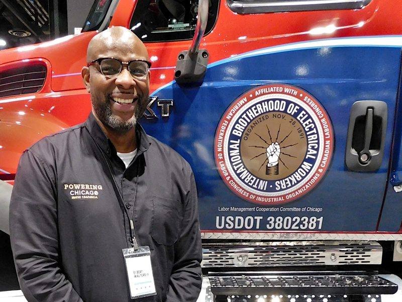 Elbert Walters III, executive director of Powering Chicago, poses with a mobile training lab at the 2023 Chicago Auto Show.