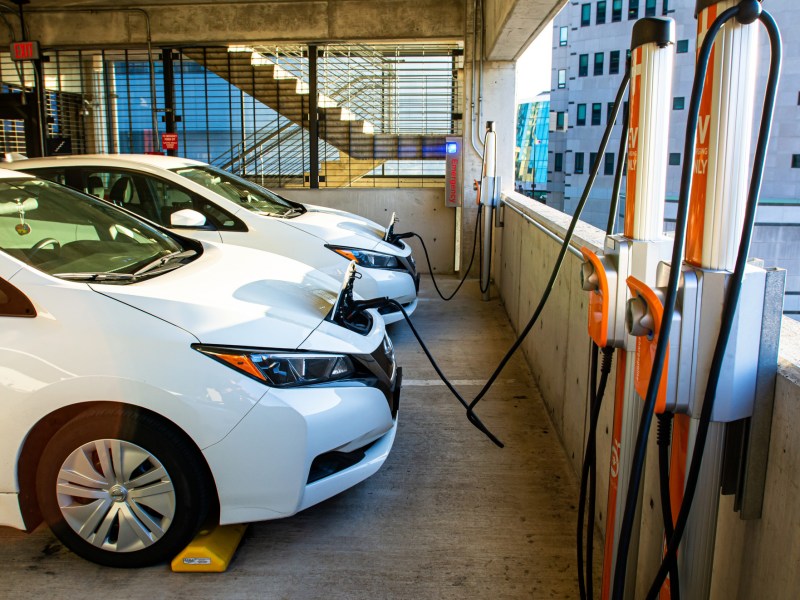 Two white Nissan Leaf electric cars charge in a parking garage in Columbus, Ohio.