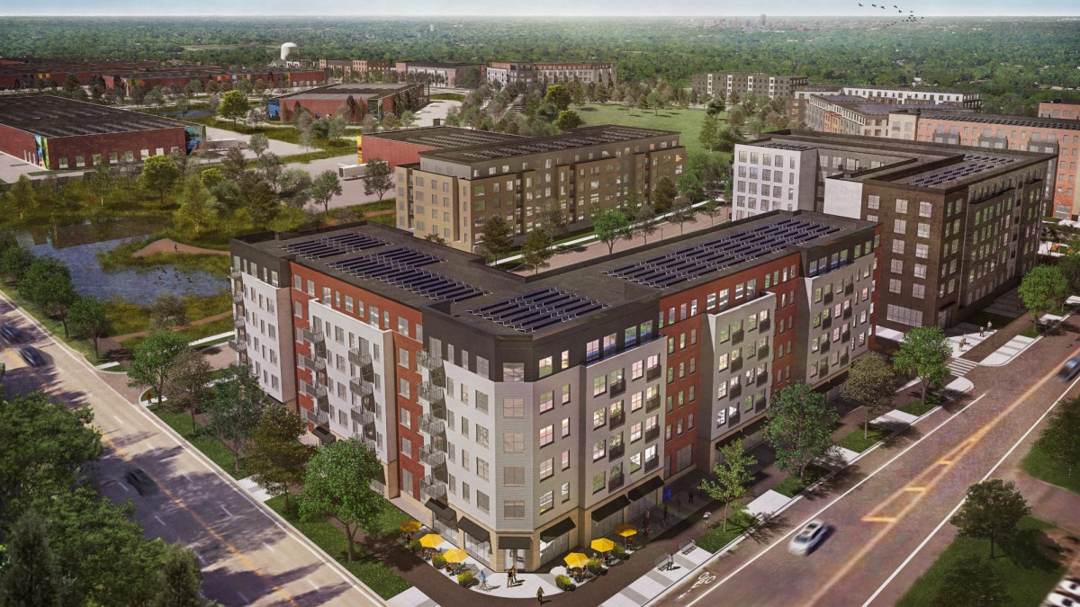 A rendering showing an aerial view of six-story block of apartments with solar panels on the roof.