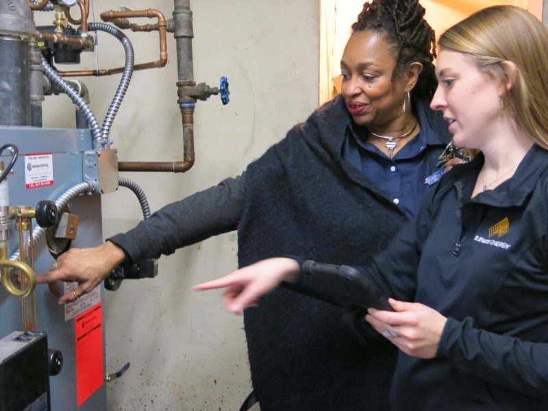 Homeowner Marcia Ellis looks at her new boiler with Elevate energy analyst Carrie Donohoe.