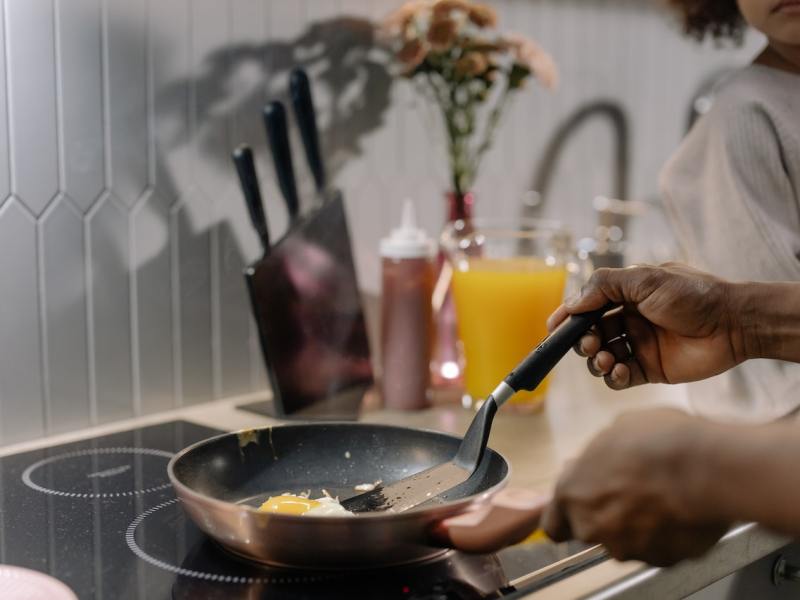 A person cooking on an induction stovetop.