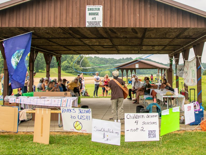 A guitarist performs for an audience of protesters at Salt Fork State Park in Ohio in July, 2023.