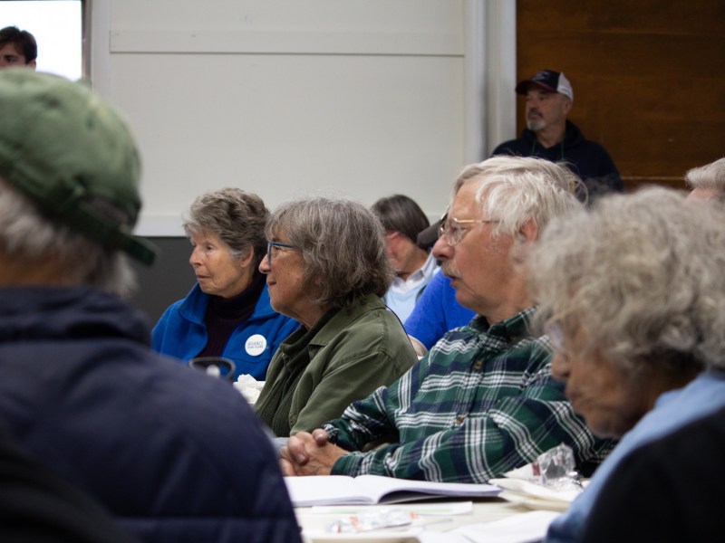 People with concerned faces at a public meeting.