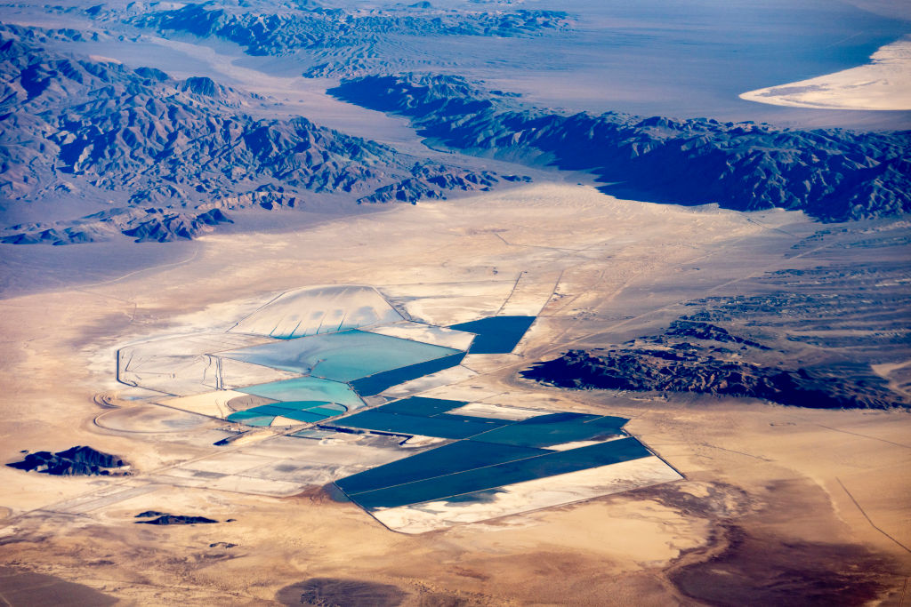 An aerial view of a lithium mine in Nevada, showing blue geometric shapes along the desert floor.