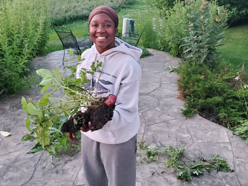 Ylanda Wilhite, photographed by her mother, holding home grown potatoes in the back yard.